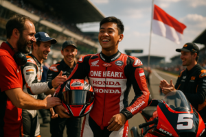 alt_text: Veda Ega Pratama tampil di panggung besar Moto3 Prancis dengan gaya penuh semangat.